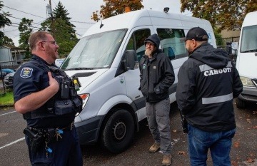 Un oficial de policía hablando con el coordinador de la Clínica White Bird y un trabajador de crisis de emergencia de Cahoots. Foto: Chris Pietsch / The Register-Guard 