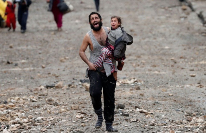 Muestra esta fotografía el dolor de un padre afgano huyendo del país con su  hija?