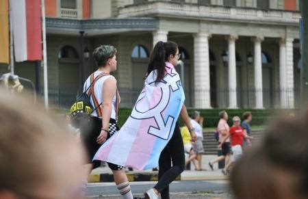 Participantes en una marcha LGBT con una bandera de orgullo trans.